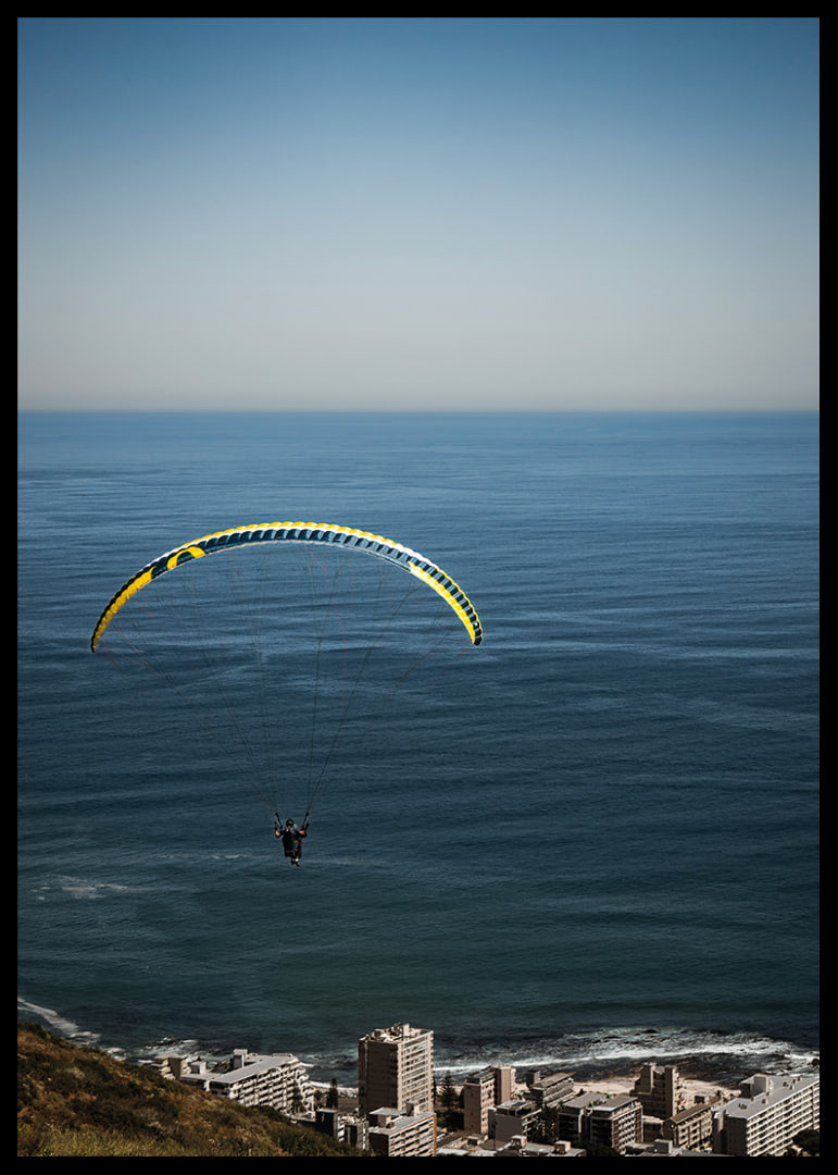 A paraglider soars majestically over the sea and the city.-12