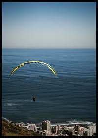 Un parapentiste plane majestueusement au-dessus de la mer et de la ville.-2