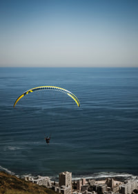 A paraglider soars majestically over the sea and the city.-7