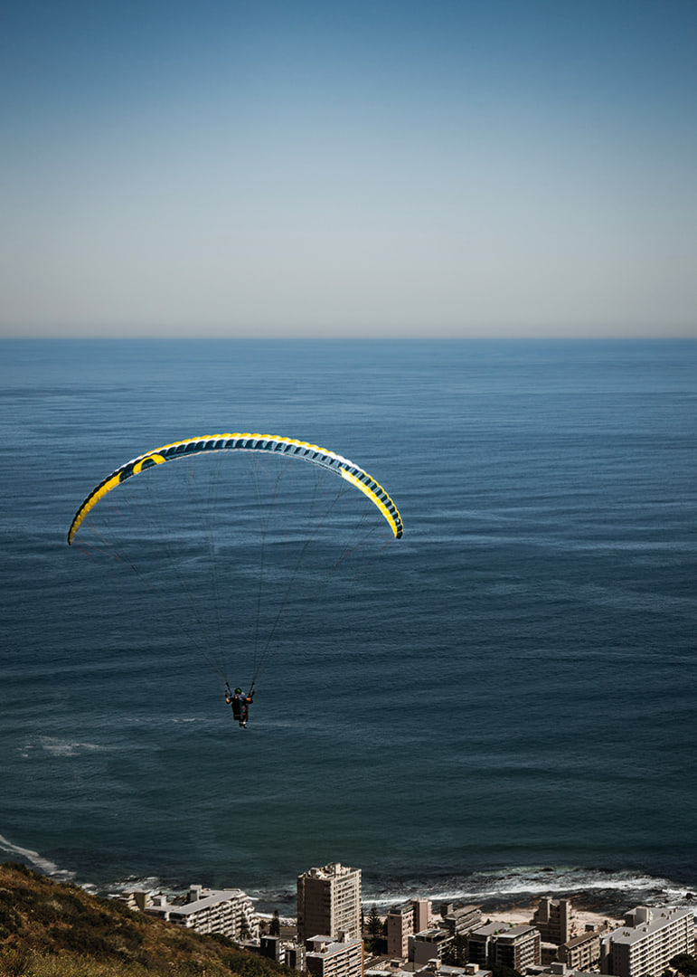 A paraglider soars majestically over the sea and the city.-12