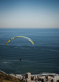 Un parapentiste plane majestueusement au-dessus de la mer et de la ville.-3