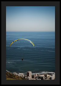 A paraglider soars majestically over the sea and the city.-0