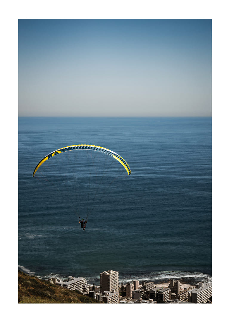A paraglider soars majestically over the sea and the city.-12