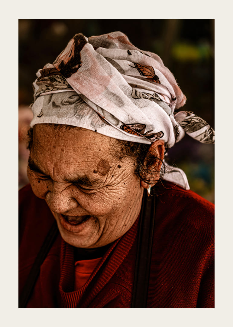 An elderly woman smiles in a warm, rustic atmosphere.-12