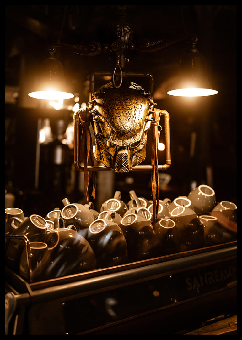 Masque scintillant sous une lumière chaude au-dessus de tasses à café.-12