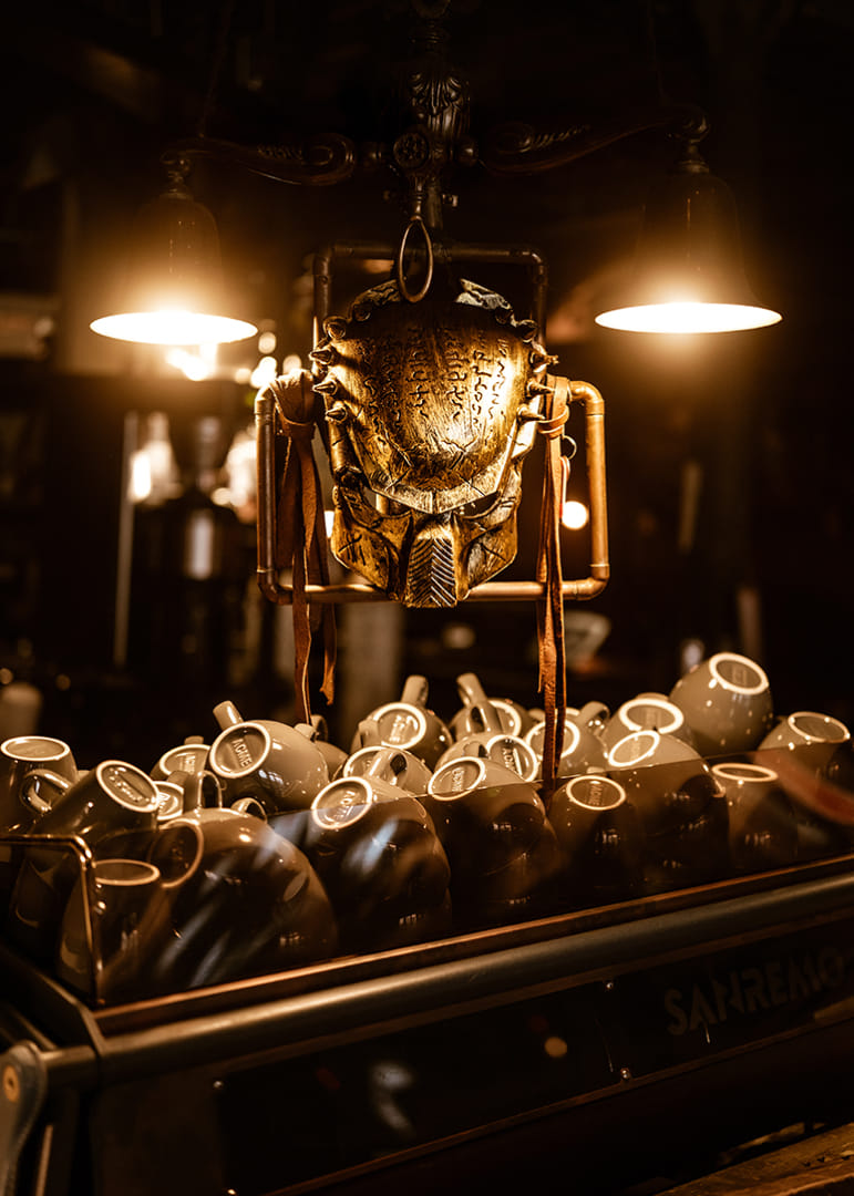 Masque scintillant sous une lumière chaude au-dessus de tasses à café.-12