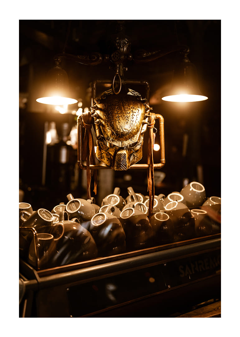 Sparkling mask in warm light above coffee cups.-12