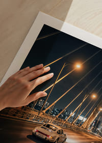 Clásico Porsche 911 en un puente iluminado hacia la ciudad por la noche.-5
