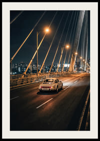 Classic Porsche 911 on an illuminated bridge towards the city at night.-2