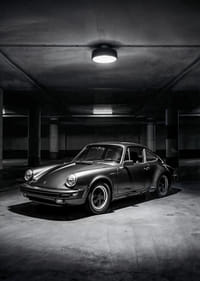 Klasisks Porsche 911, kas novietots noslēpumaini apgaismotā garāžā.-3