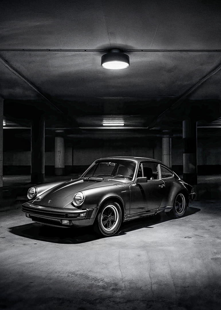 Klasisks Porsche 911, kas novietots noslēpumaini apgaismotā garāžā.-12