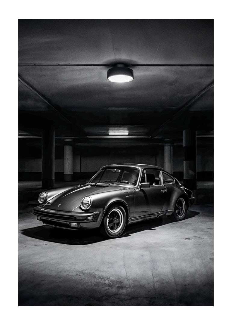 Klasikinis „Porsche 911“ automobilis pastatytas paslaptingai apšviestame garaže.-12