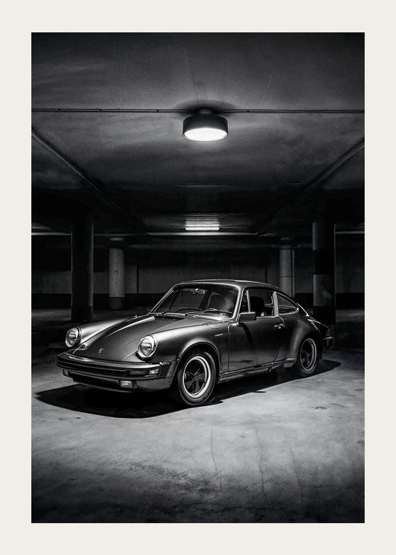 En klassisk Porsche 911 parkerad i ett mystiskt upplyst garage.-12