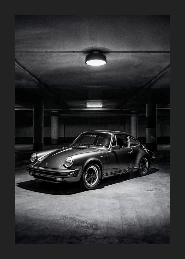 Klasikinis „Porsche 911“ automobilis pastatytas paslaptingai apšviestame garaže.-12