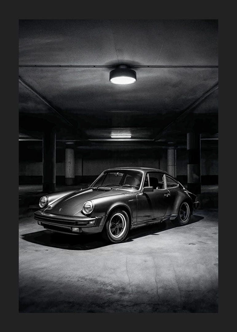 En klassisk Porsche 911 parkerad i ett mystiskt upplyst garage.-12