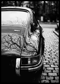 En klassisk Porsche 911 skapar en nostalgisk känsla på kullerstensgatan.-6