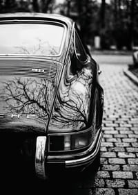 Klasisks Porsche 911 rada nostalģisku sajūtu uz bruģakmens ielas.-3