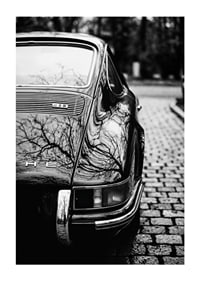 En klassisk Porsche 911 skapar en nostalgisk känsla på kullerstensgatan.-1
