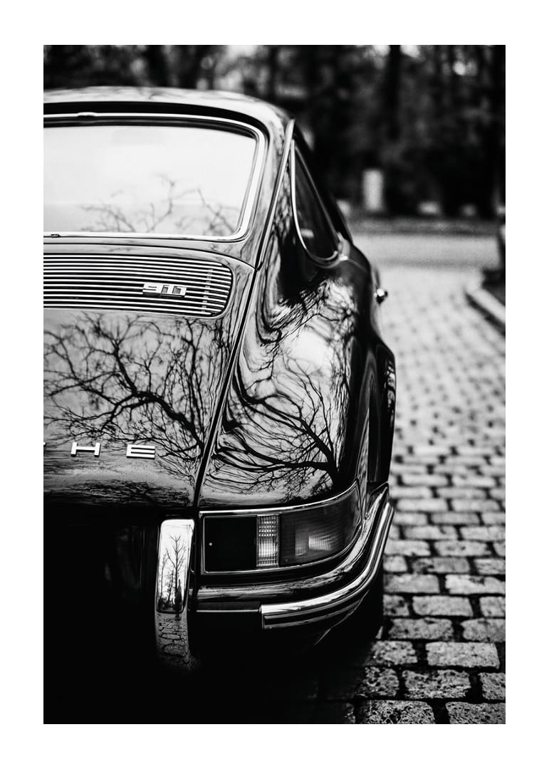 Klasisks Porsche 911 rada nostalģisku sajūtu uz bruģakmens ielas.-12