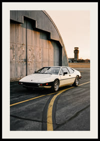 Elegant klassisk Lotus Esprit framför industribyggnad i solnedgång.-2