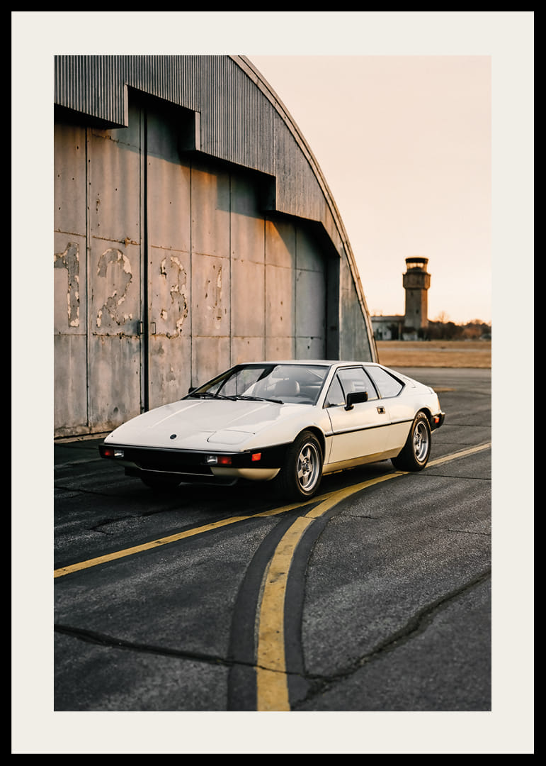 Elegant klassisk Lotus Esprit framför industribyggnad i solnedgång.-12