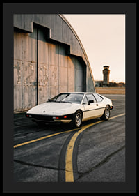Elegant classic Lotus Esprit in front of industrial building at sunset.-4