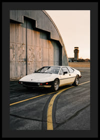 Elegant klassisk Lotus Esprit framför industribyggnad i solnedgång.-4