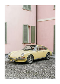 A charming pastel yellow Porsche 911 in front of a pink wall gives a retro feel.-1