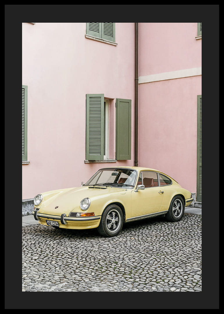 A charming pastel yellow Porsche 911 in front of a pink wall gives a retro feel.-12