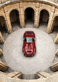 Sarkans klasisks Ferrari 250 GTO majestātiskā pagalmā.-3