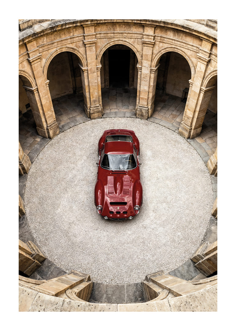 Sarkans klasisks Ferrari 250 GTO majestātiskā pagalmā.-12