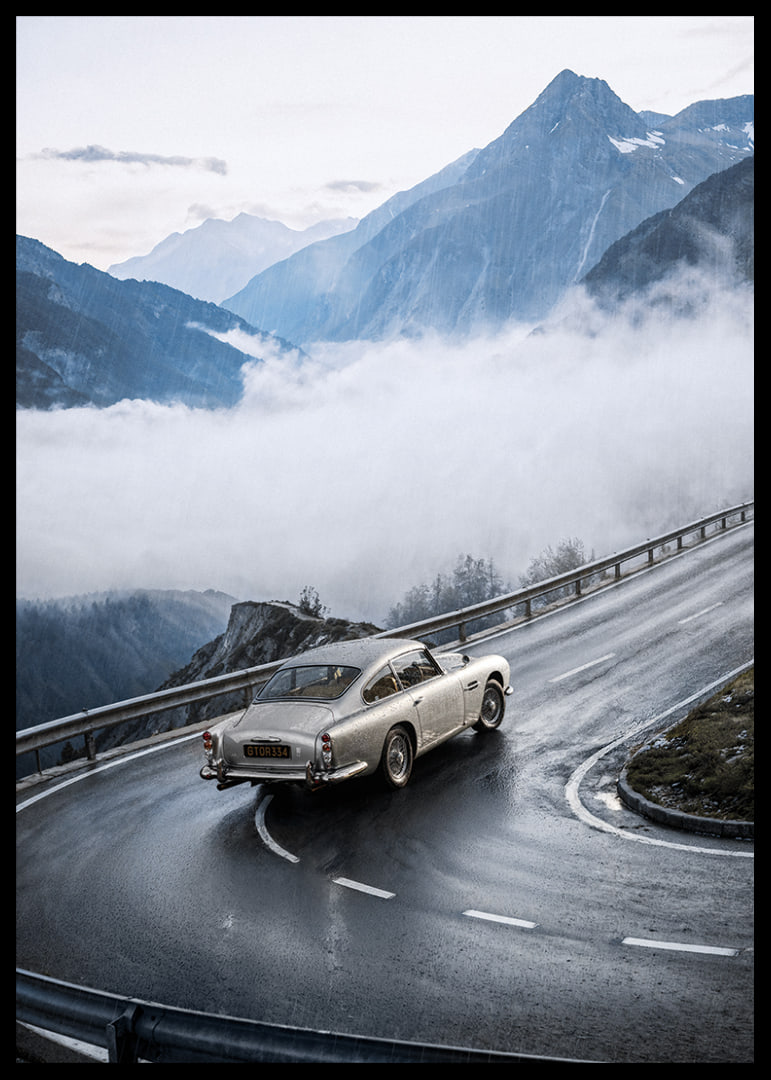 En klassisk Aston Martin DB5 färdas genom dimmiga berg på en slingrande väg.-12