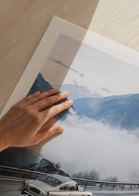 Une Aston Martin DB5 classique traverse des montagnes brumeuses sur une route sinueuse.-5