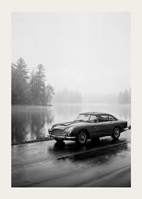 A classic Aston Martin DB5 by a foggy seaway exudes calm and nostalgia.-3