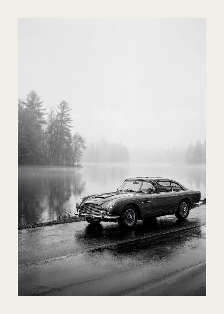 En klassisk Aston Martin DB5 vid en dimmig sjöväg utstrålar lugn och nostalgi.-12