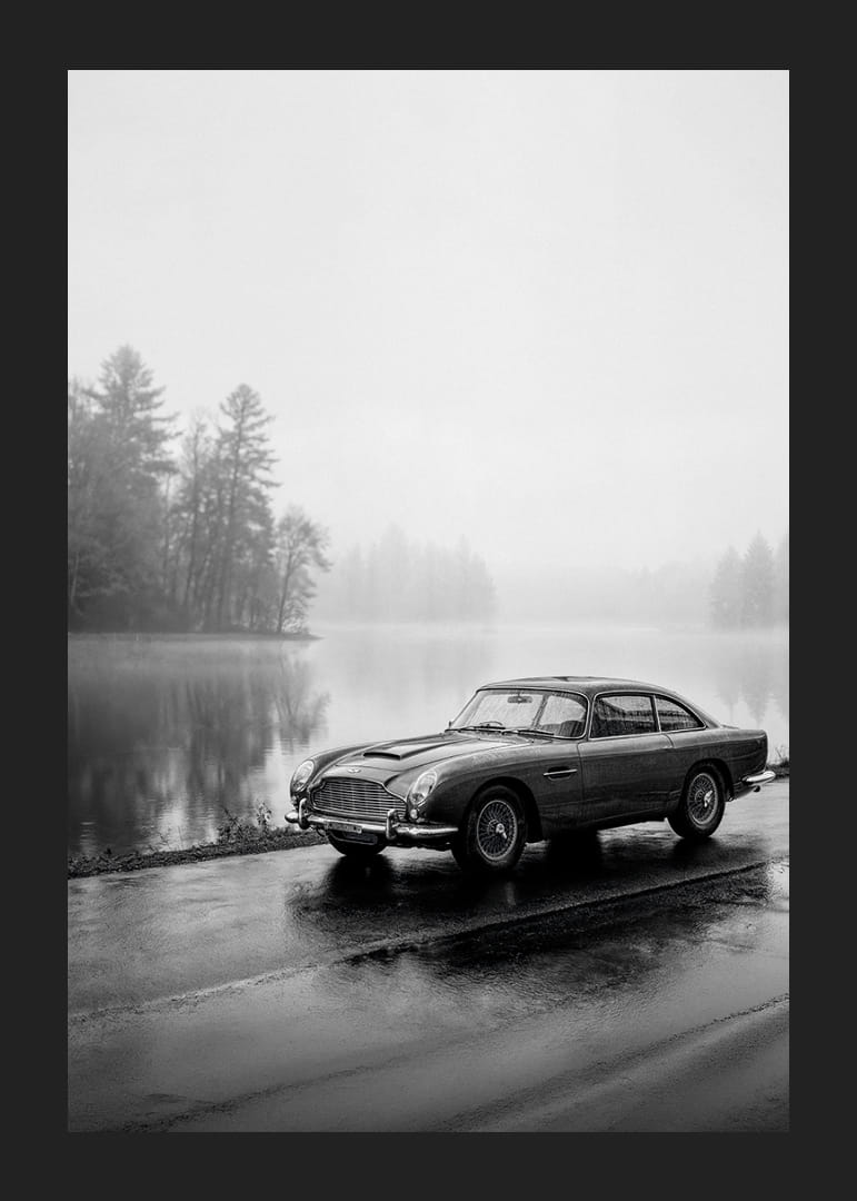 En klassisk Aston Martin DB5 vid en dimmig sjöväg utstrålar lugn och nostalgi.-12