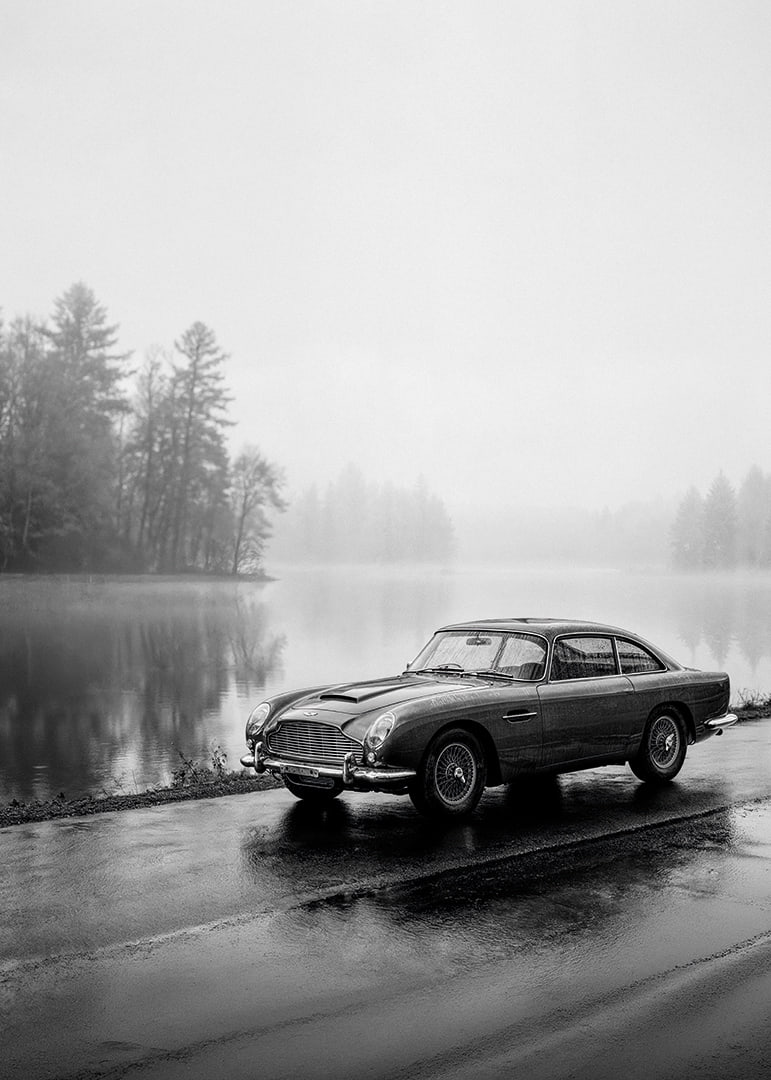 A classic Aston Martin DB5 by a foggy seaway exudes calm and nostalgia.-12