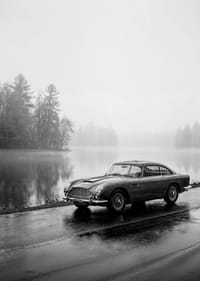 Une Aston Martin DB5 classique, au bord d'une mer brumeuse, dégage une impression de calme et de nostalgie.-3