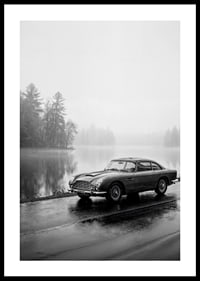 A classic Aston Martin DB5 by a foggy seaway exudes calm and nostalgia.-0