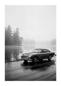 Une Aston Martin DB5 classique, au bord d'une mer brumeuse, dégage une impression de calme et de nostalgie.-1