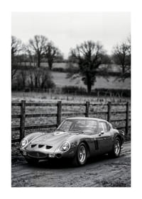 En klassisk Ferrari 250 GTO står ståtlig på en grusväg omgiven av träd.-1