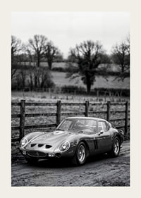 En klassisk Ferrari 250 GTO står ståtlig på en grusväg omgiven av träd.-3