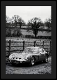 En klassisk Ferrari 250 GTO står ståtlig på en grusväg omgiven av träd.-4