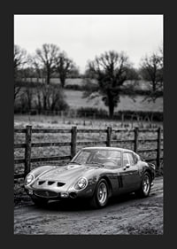 En klassisk Ferrari 250 GTO står ståtlig på en grusväg omgiven av träd.-5