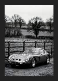 En klassisk Ferrari 250 GTO står ståtlig på en grusväg omgiven av träd.-5