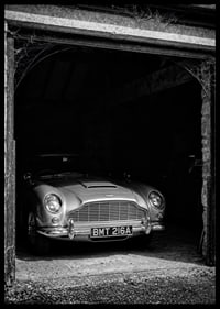 A classic Aston Martin DB5 proudly parked in a nostalgic garage.-6