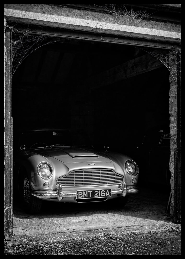 A classic Aston Martin DB5 proudly parked in a nostalgic garage.-12