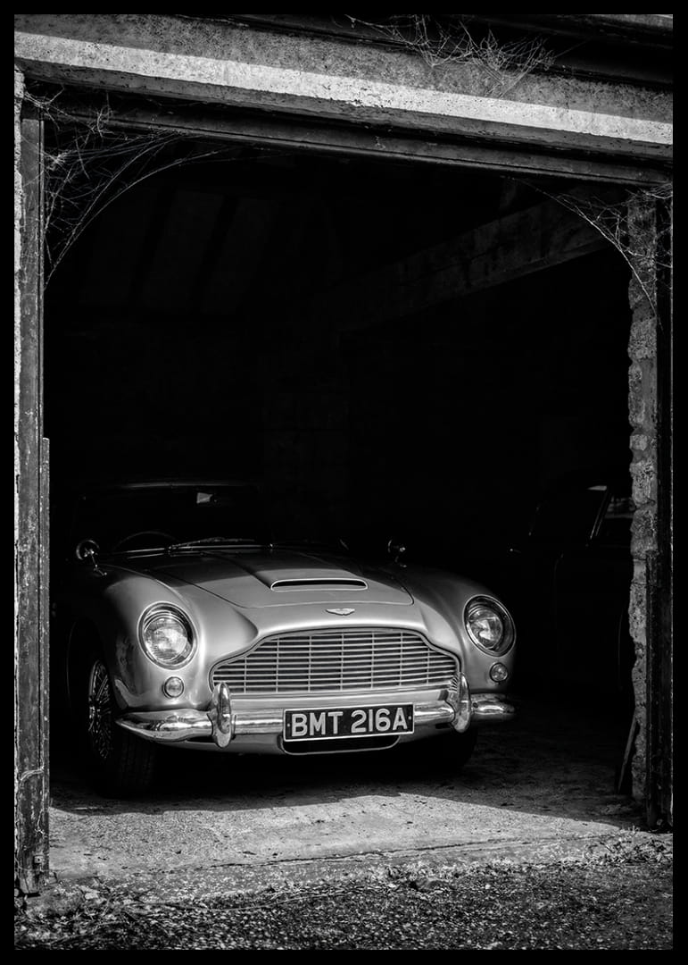 En klassisk Aston Martin DB5 stolt parkerad i ett nostalgiskt garage.-12