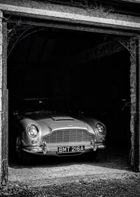 A classic Aston Martin DB5 proudly parked in a nostalgic garage.-7
