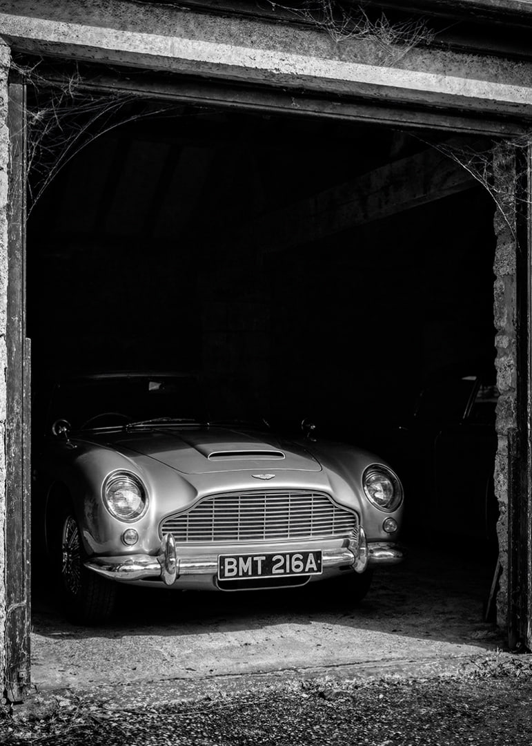 A classic Aston Martin DB5 proudly parked in a nostalgic garage.-12